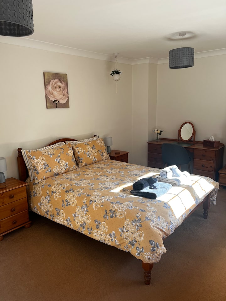 Priestranná hlavná spálňa s manželskou posteľou a dostatkom priestoru na cestovnú detskú postieľku. 