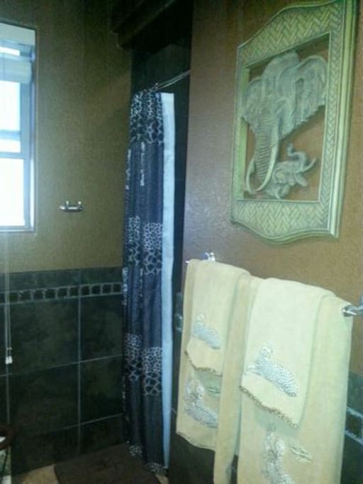 Spacious bathroom with walk-in tile shower.