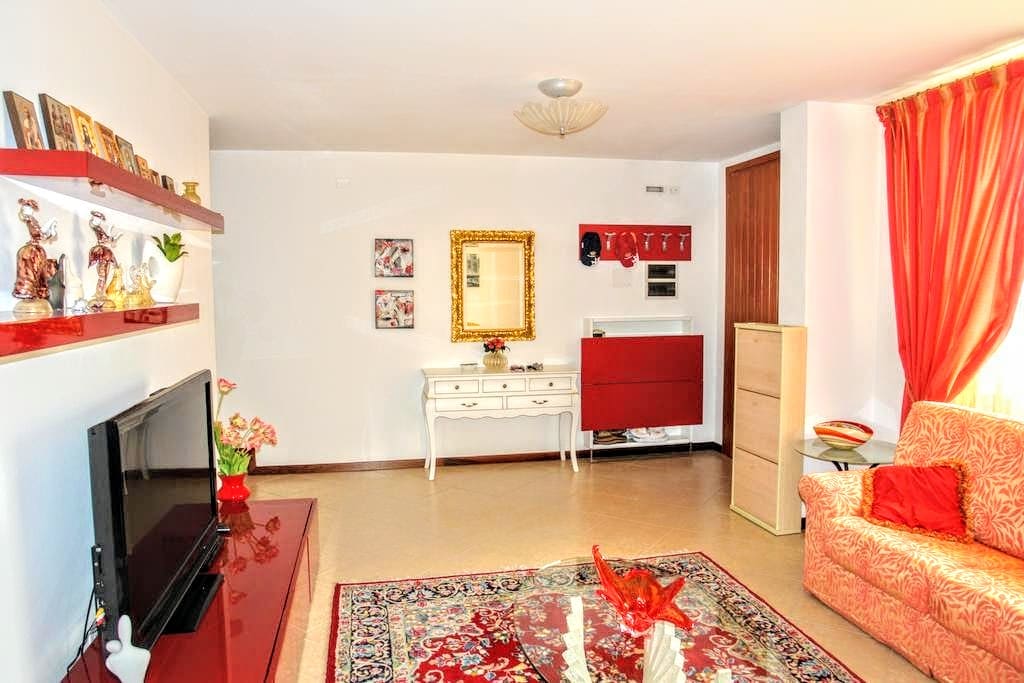 Enter in the living room with antique and modern furnitures with a comfortable sofa and satellite TV.