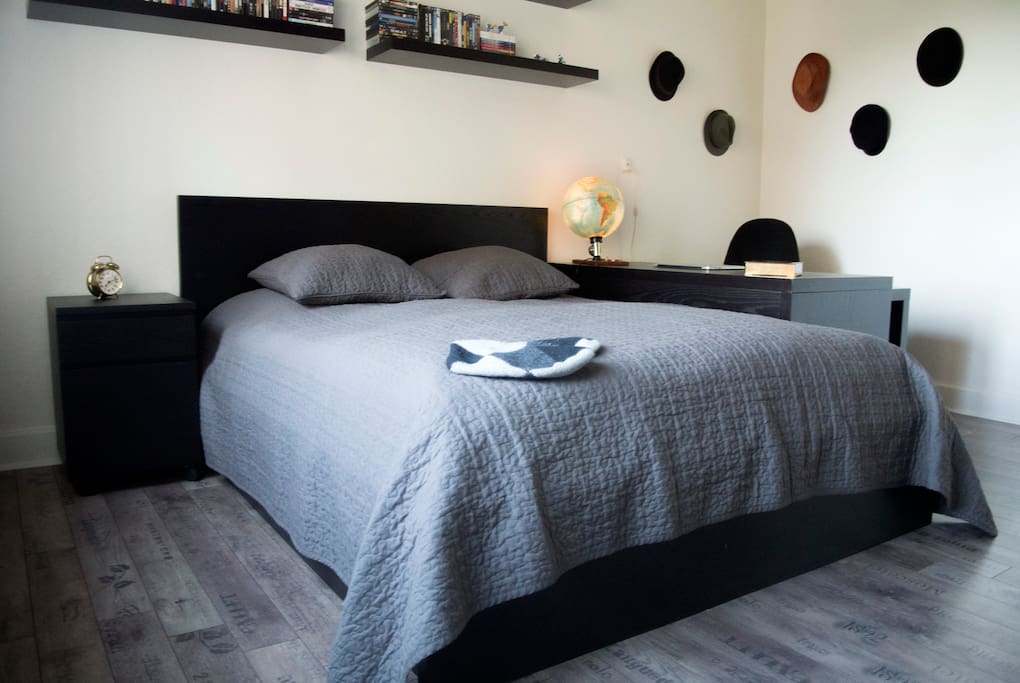 Large bedroom with a great workspace and a double bed