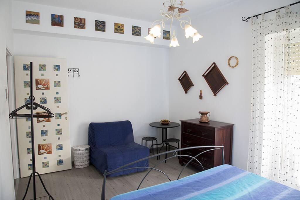 Lo stile mediterraneo è rappresentato dalla bella porta decorata, gli strumenti musicali appesi al muro e le ceramiche