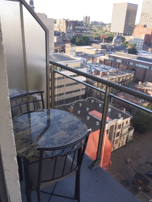 Balcon en hauteur accomodé avec une table et 2 chaises