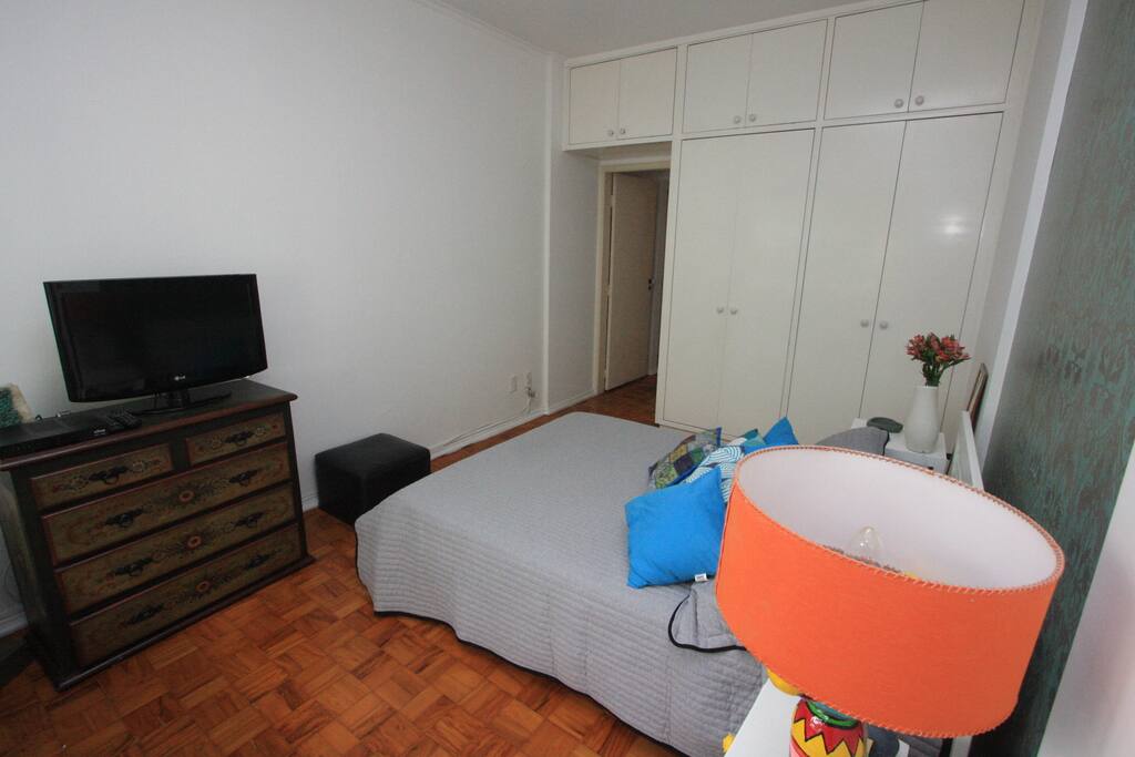 Quarto com TV a cabo e armários
