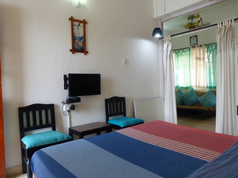 Bedroom with LCD TV and satellite connection. You can also see the living room sofa