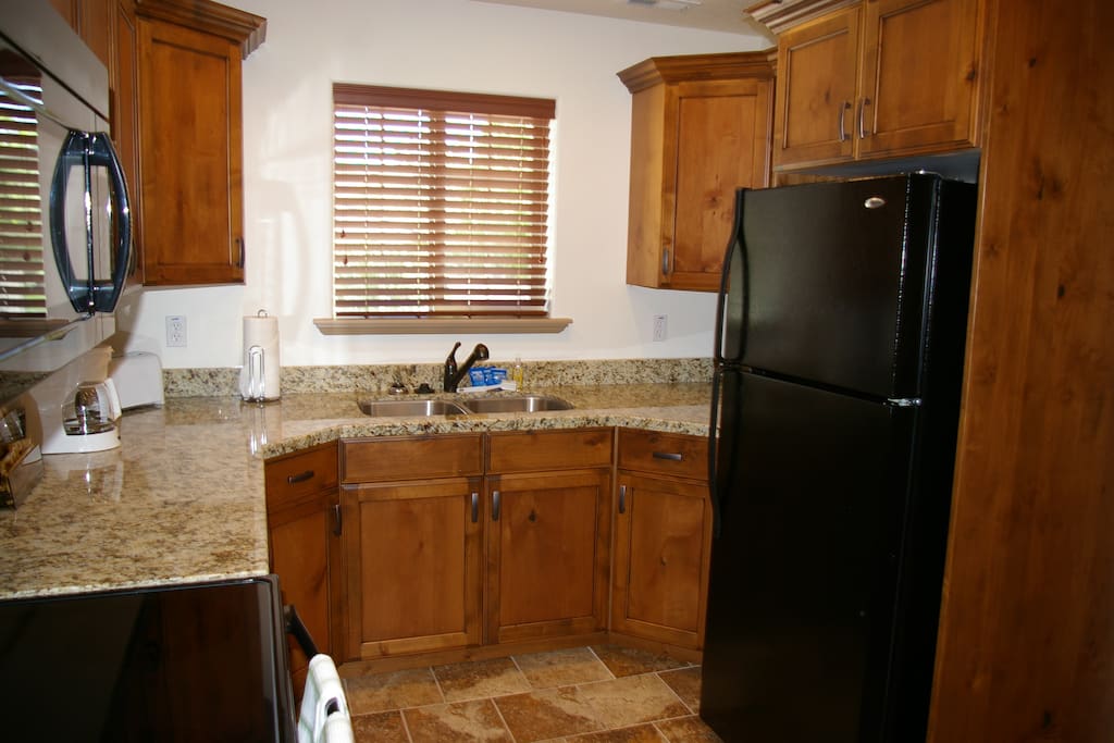Large kitchen with granite countertops, fridge, cooktop, oven, and microwave. Includes all cookware and place settings you'll need.
