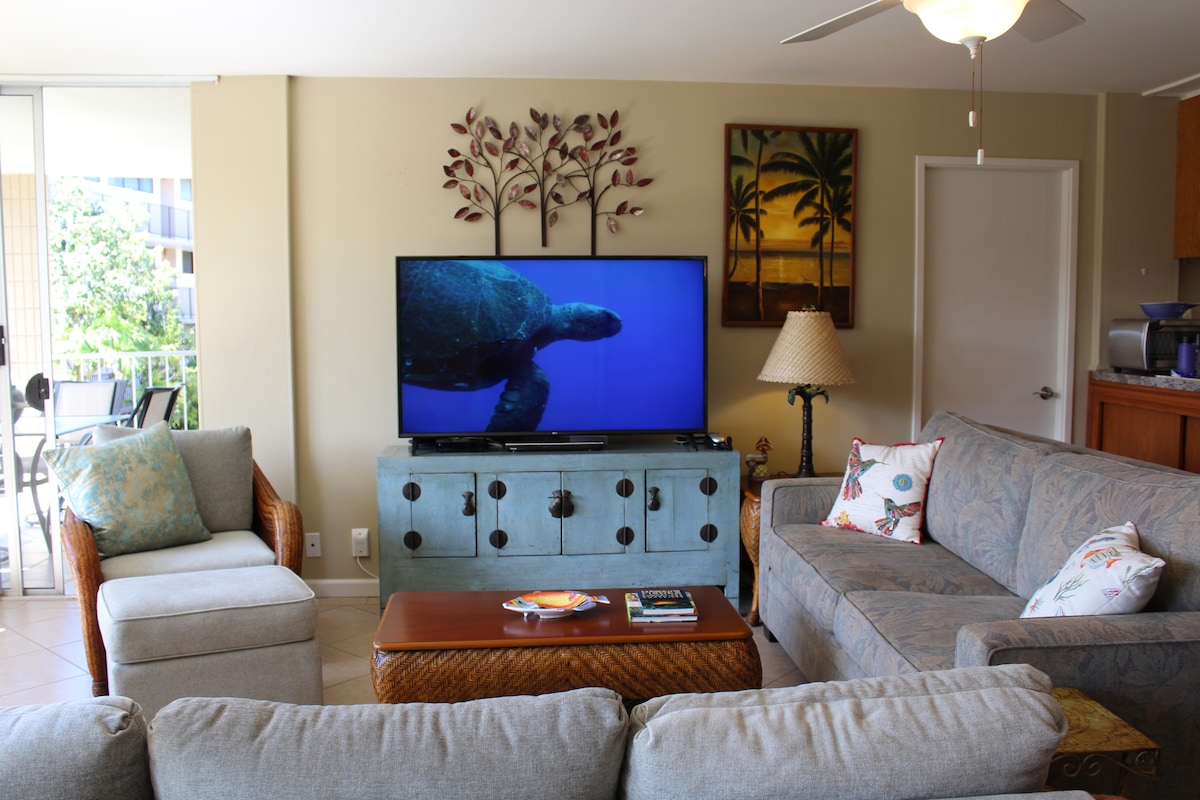 טלוויזיה חכמה עם מסך גדול והרבה מקומות ישיבה בסלון.