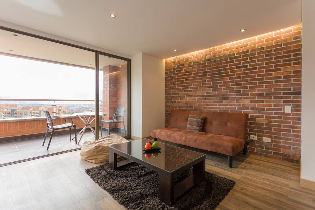 Sala con sofá cama y balcón. Living room with sofa bed and balcony