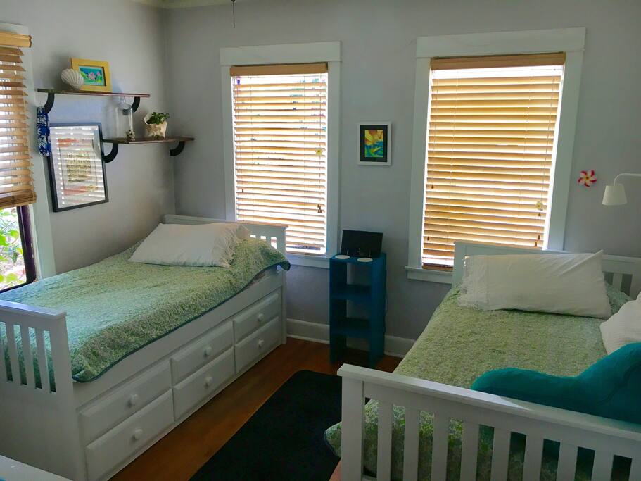 Bright front bedroom with ceiling fan overlooking front porch courtyard patio