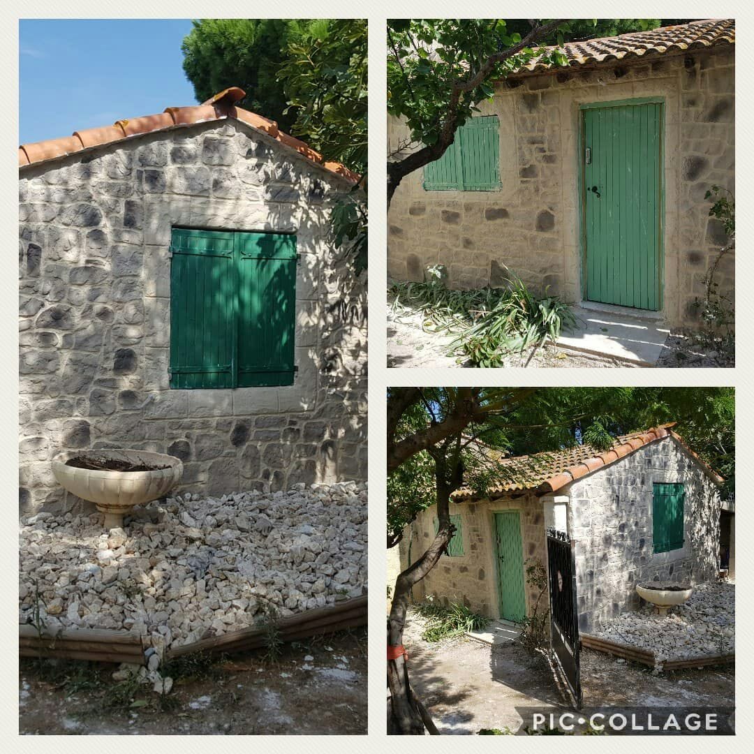 A quaint stone structure is captured from multiple angles, showcasing a textured exterior with a green door and matching shutters. Pebbles and a stone planter are present in the foreground, surrounded by greenery, enhancing the property's charm in a tranquil setting.
