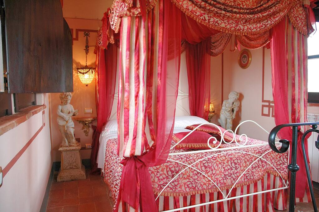 "Alba":
this is a major suite. Built on two levels, from the turret of the farmhouse there is an enchanting view. The princely four-poster bed will enclose you in a red and white cloud, while on either side of the bed statues of angels will guard you as you sleep! No attention to detail has been spared in order to make your stay as comfortable as possible, including a large fireplace on the first floor to warm your winter evenings.
View of Lake Trasimeno. Air conditioning, fireplace, tv, electric kettle for hot drinks.
Veramente importante questa suite su due livelli che si affaccia dalla torretta del casale, aprendosi su di un panorama incantato. Il baldacchino principesco del letto vi avvolgerà in una nuvola rossa e bianca, mentre ai suoi lati statue di amorini sorveglieranno il vostro riposo. Particolarmente attenta ai particolari, la suite gode nel suo piano sottostante di un grande camino, che renderà piacevoli anche le serate invernali.
Vista Lago Trasimeno. Aria condizionata, camino, tv, bollitore.