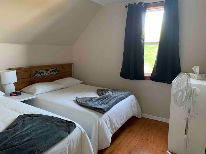 חדר שינה קדמי המשקיף על הנהר עם מיטת קווין סייז ומיטה זוגית 