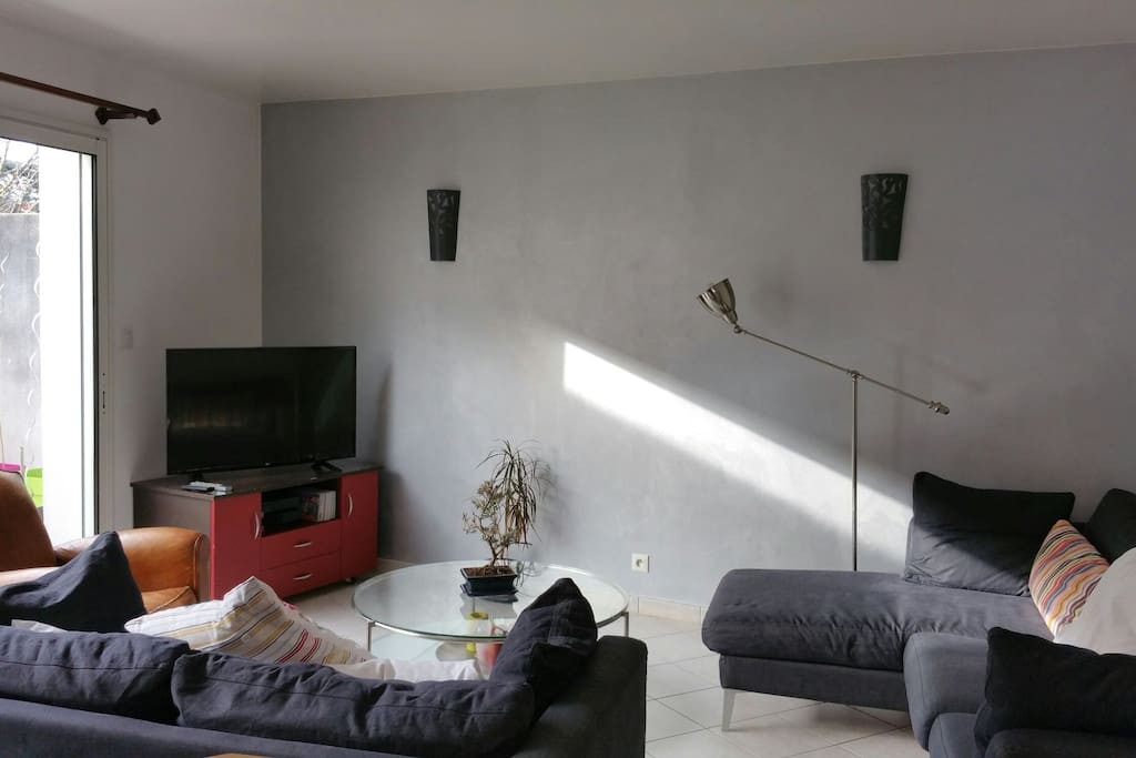 Salon avec télévision, free box et wifi, DVD pour enfants, 2 canapés non convertibles, baie vitrée donnant sur jardin