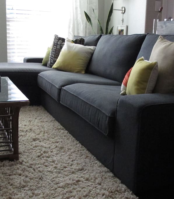 Comfy couch in living room with large flat screen with cable