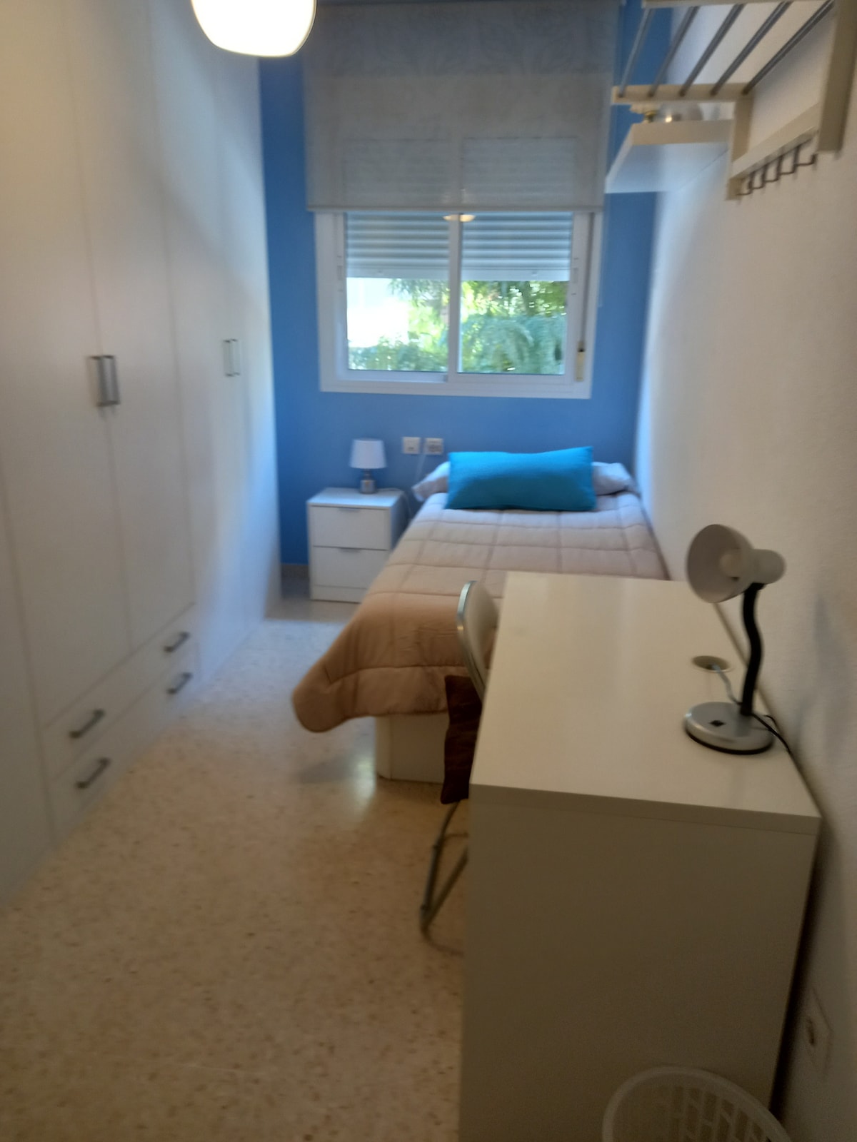 חדר שינה עם מיטת יחיד, שולחן עבודה וארון גדול