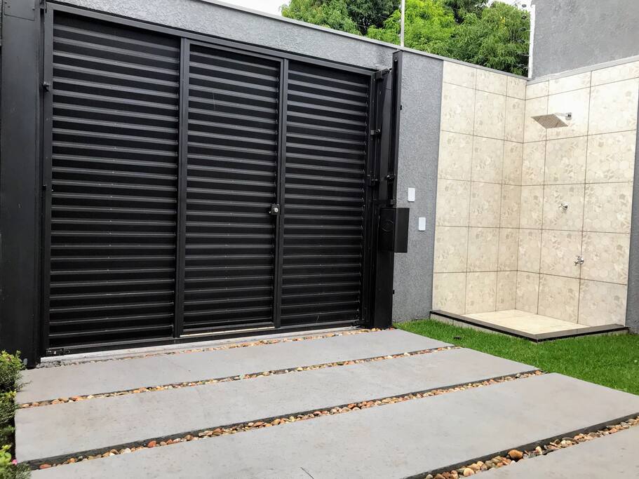 Jardim com chuveirão, portão de garagem automático para carga e descarga, e portão social. Total privacidade.