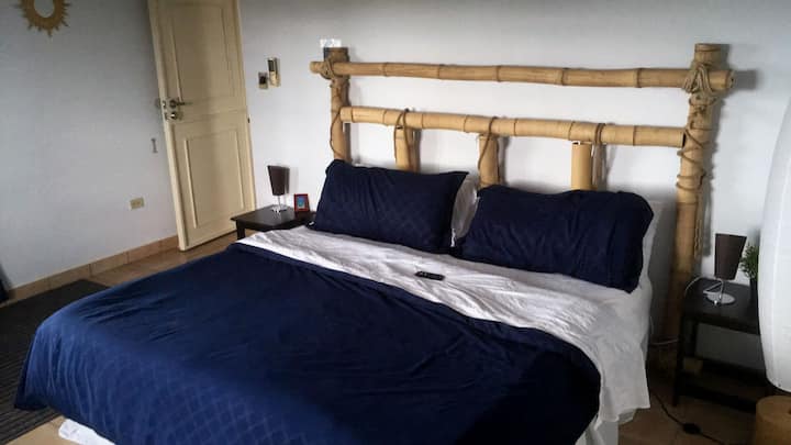 Master bedroom with king size bed, handmade bamboo headboard