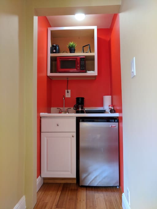 A one burner kitchenette with utensils to cook, coffee maker, refrigerator, microwave and toaster.