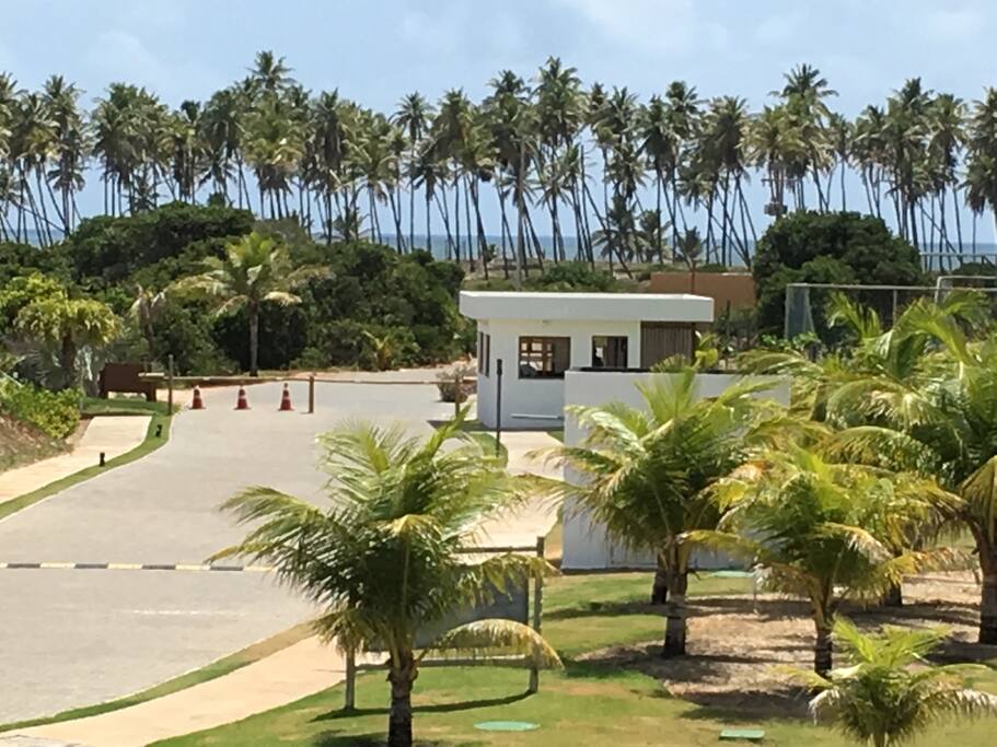A vista da janela da suíte, com destaque para a entrada do condomínio, próximo ao mar.