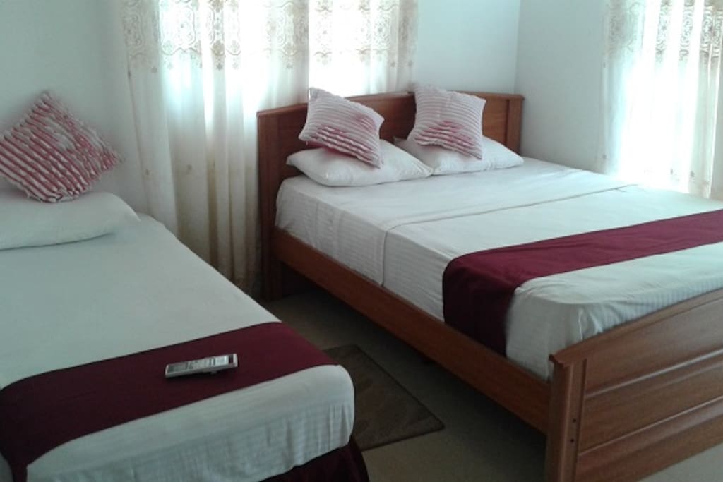 one single and one double bed in the bedroom