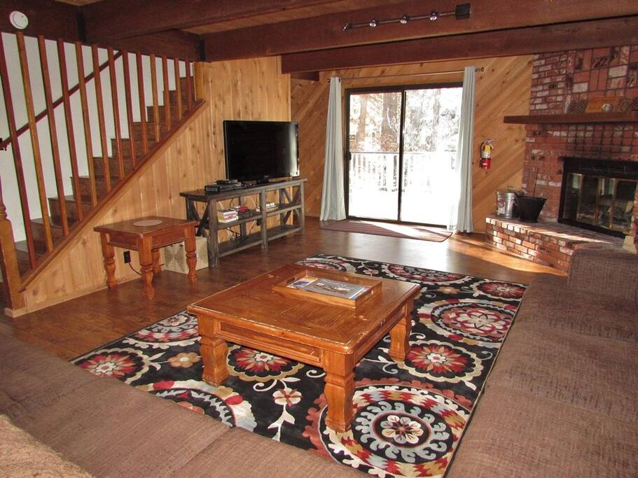 Comfortable living room has wood burning fireplace