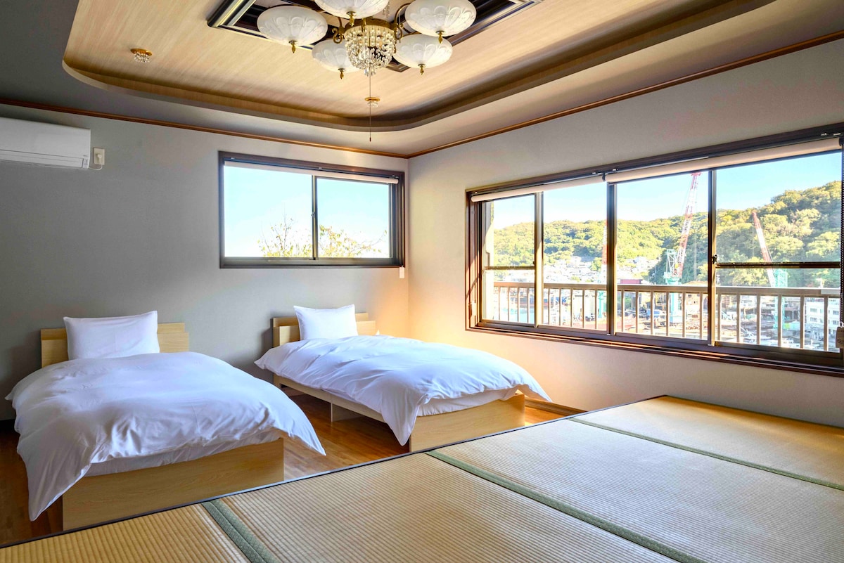 寝室#2　こちらは2階の階段を上がってすぐのお部屋です。小上がりがある和洋室で、ベッド2台と人数によって小上がりにお布団をご用意します。