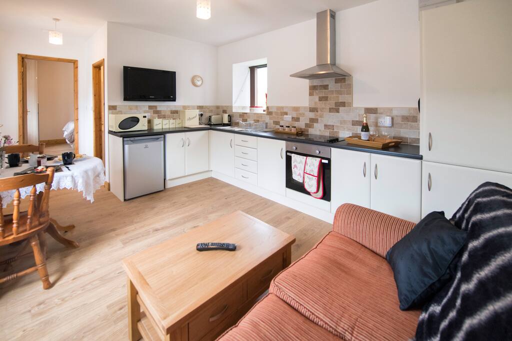 Comfortable lifestyle lounge/dining/kitchen with far reaching views, dining table for 2 guests, comfy seating and wall mounted TV.