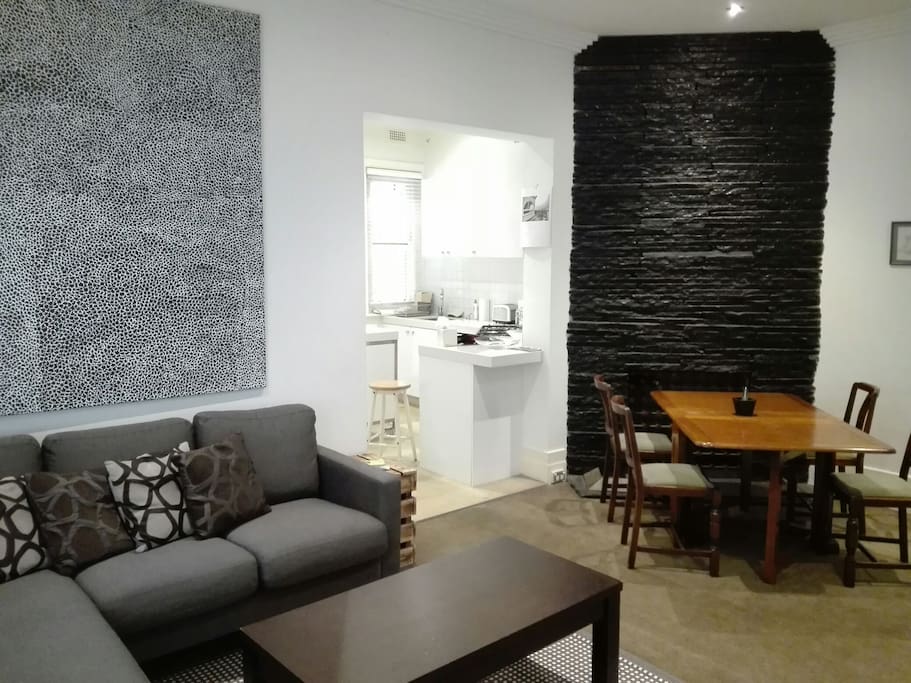 Lounge sofa couch with chaise, a beautiful black & white painting, and a feature black wall facing dining table (just next the kitchen)