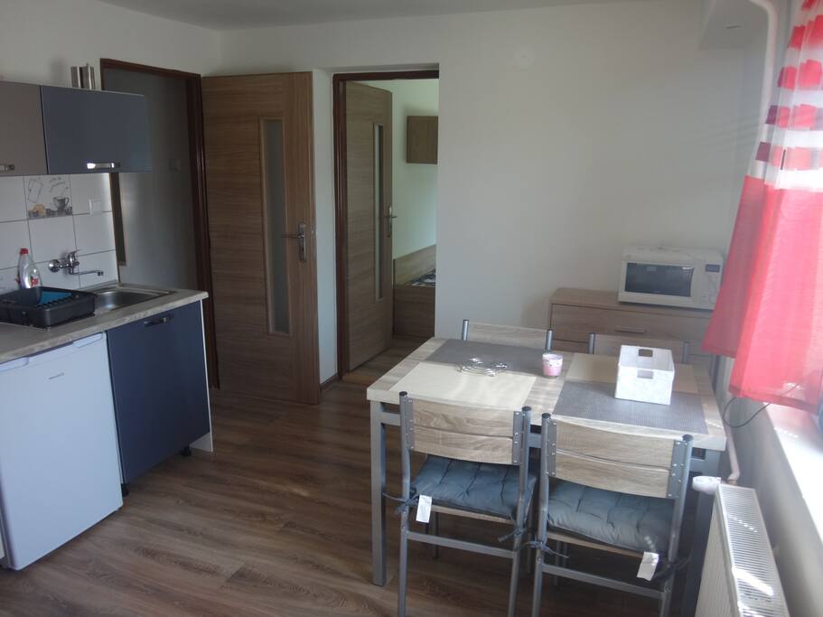 Obývacia miestnosť spojená s kuchyňou a vchodom do apartmánu