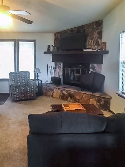 Living room view with smart TV and wood burning fireplace