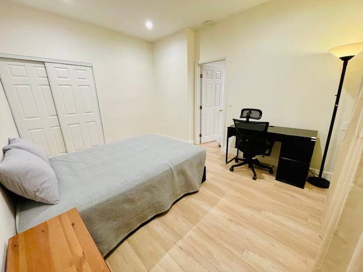 Lichte slaapkamer met eigen werkruimte.