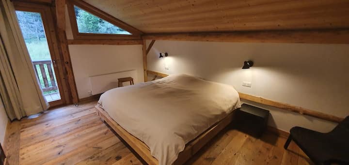 מיטה זוגית עם חדר רחצה פרטי.