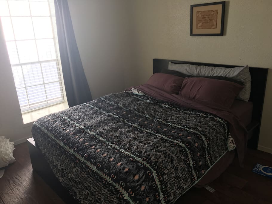 Queen bed in bright bedroom (blackout shade can be pulled close to sleep in.)