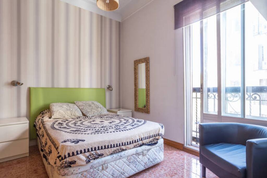Dormitorio con armario empotrado, butaca, aire acondicionado, calefacción y gran ventanal