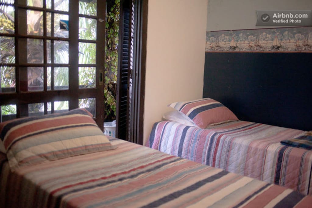 Quarto 02 - Possui duas camas de solteiro e uma caminha auxiliar (que sai de baixo de uma destas). Este quarto possui sacada com vista para o mar! Ainda com roupeiro, escrivaninha, cadeira.