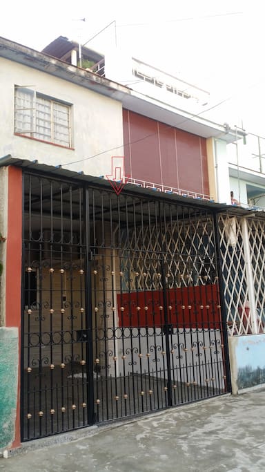 View of Pablo's apartment from outside. Pablo lives upstairs where brown curtain is hanging