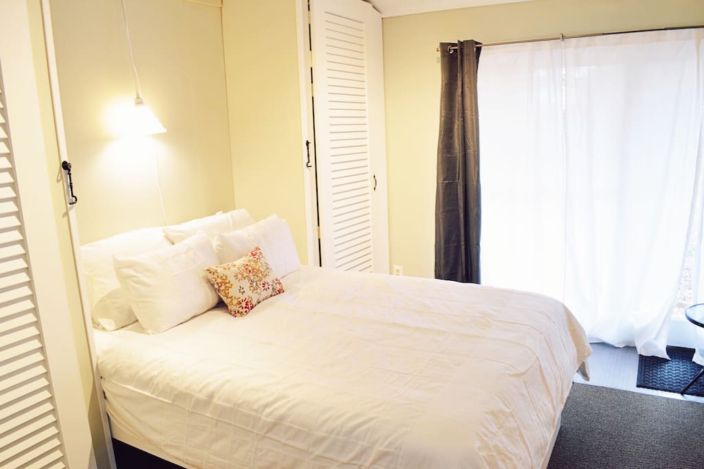 Queen size Murphy bed with seating area with private door and backyard access.