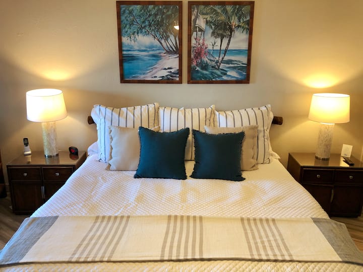 Dormitorio principal extra grande con cama tamaño king, ventilador y TV.