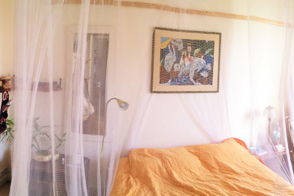 The bedroom with a mosquito net and a big closet