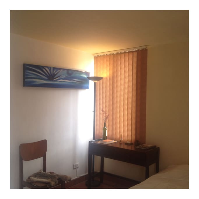 Bedroom with desk, chair and lamp.