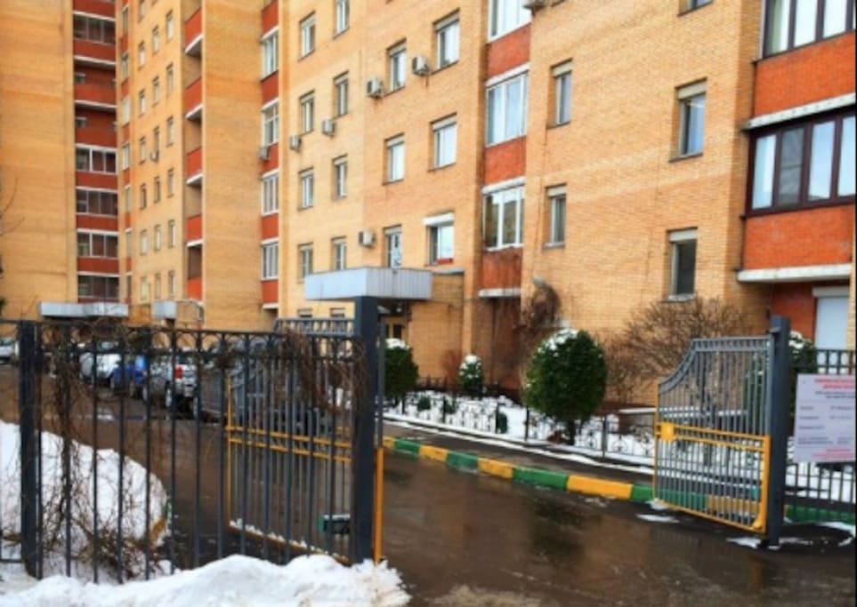 The entrance to the house and the parking lot. The house is a guarded apartment building // Вход к подъезду и на парковку. Дом охраняемый.