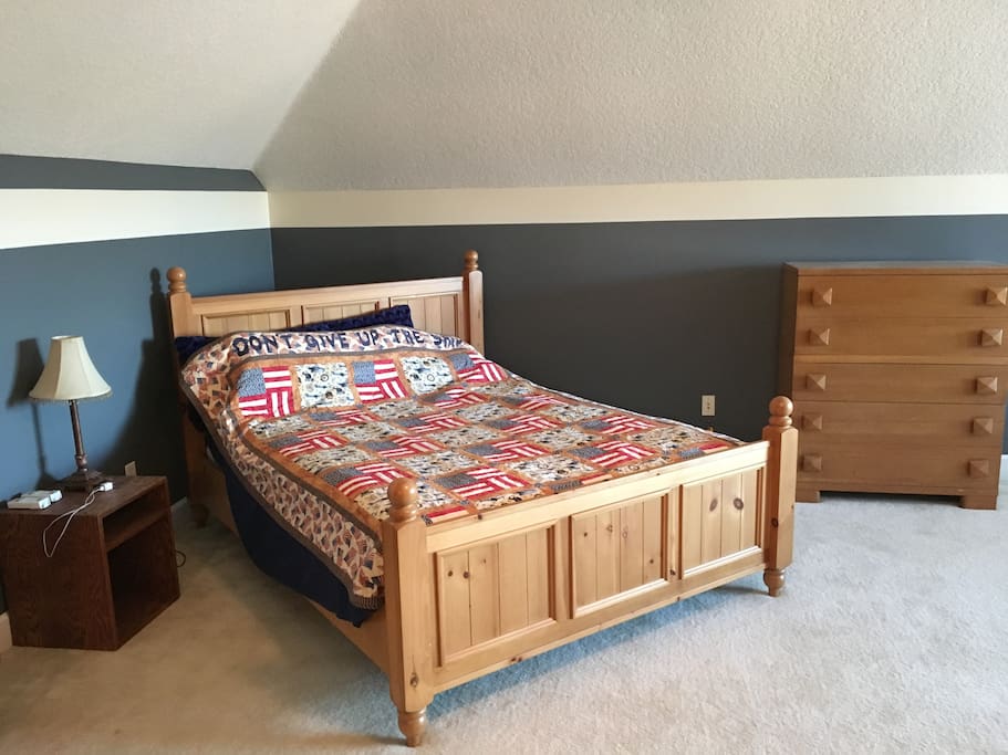 Queen size bed with big dresser in a bright space