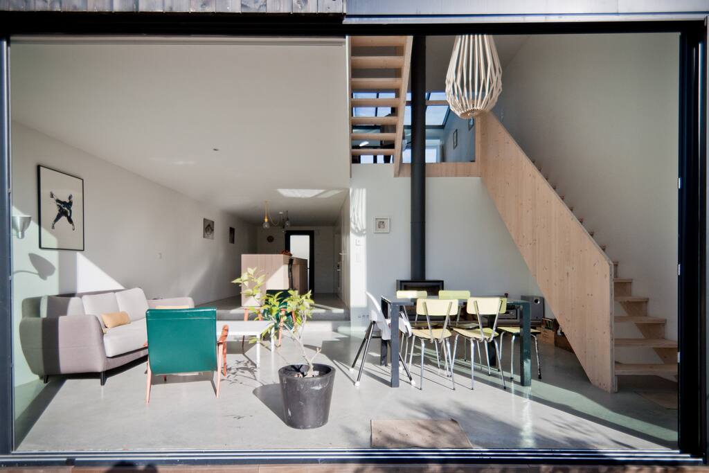Trois niveaux, maison traversante, béton ciré, poêle scandinave, cuisine bar.