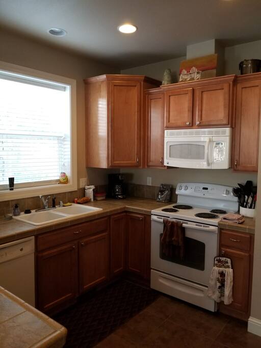 Kitchen complete with dishwasher, stove, microwave, and fridge.