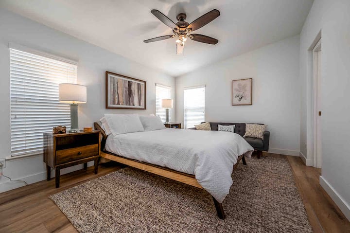 Primary Bedroom with Comfortable Queen Bed, Walk in Closet, Twin Futon, Ceiling fan, and Bathroom.