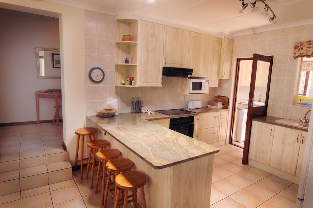 Kitchen with door onto scullery (dishwasher, washing machine and dryer), 2 fridges, oven, stove top & microwave.