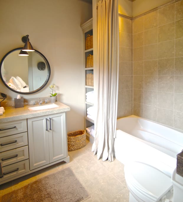 Bathroom with deep soaking tub and shower, Limestone counter tops and tiles, fully stocked with plush cotton towels and bathrobes. Stocked with amenities for your stay.
