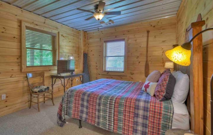 ห้องนอนชั้นล่างพร้อมเตียงขนาดควีนไซส์และโทรทัศน์