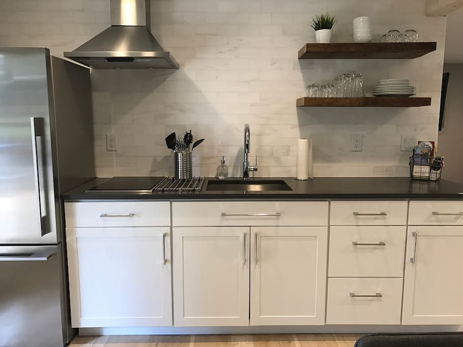 Cute new kitchen with a full sized refrigerator, cooktop, microwave & countertop oven for minimal cooking/baking.
Note: no built in conventional oven or dishwasher.