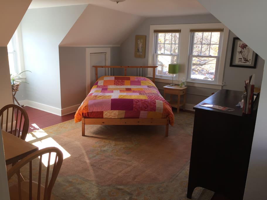 Full sized bed in room with kitchenette and dinning area