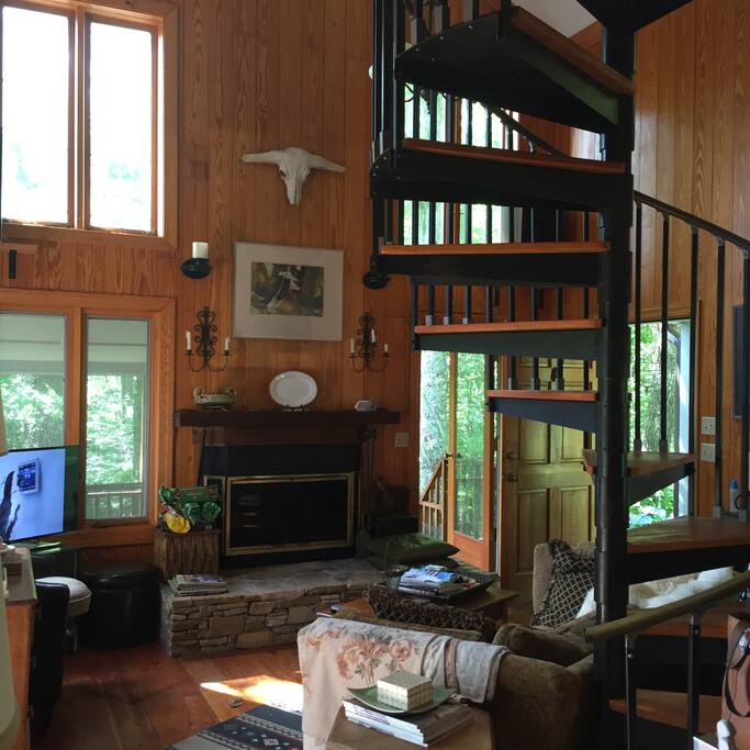 The living room ceiling soars and is flooded with light from all the large windows. You feel like the outside is coming in!
The spiral staircase leads up to the twin beds.